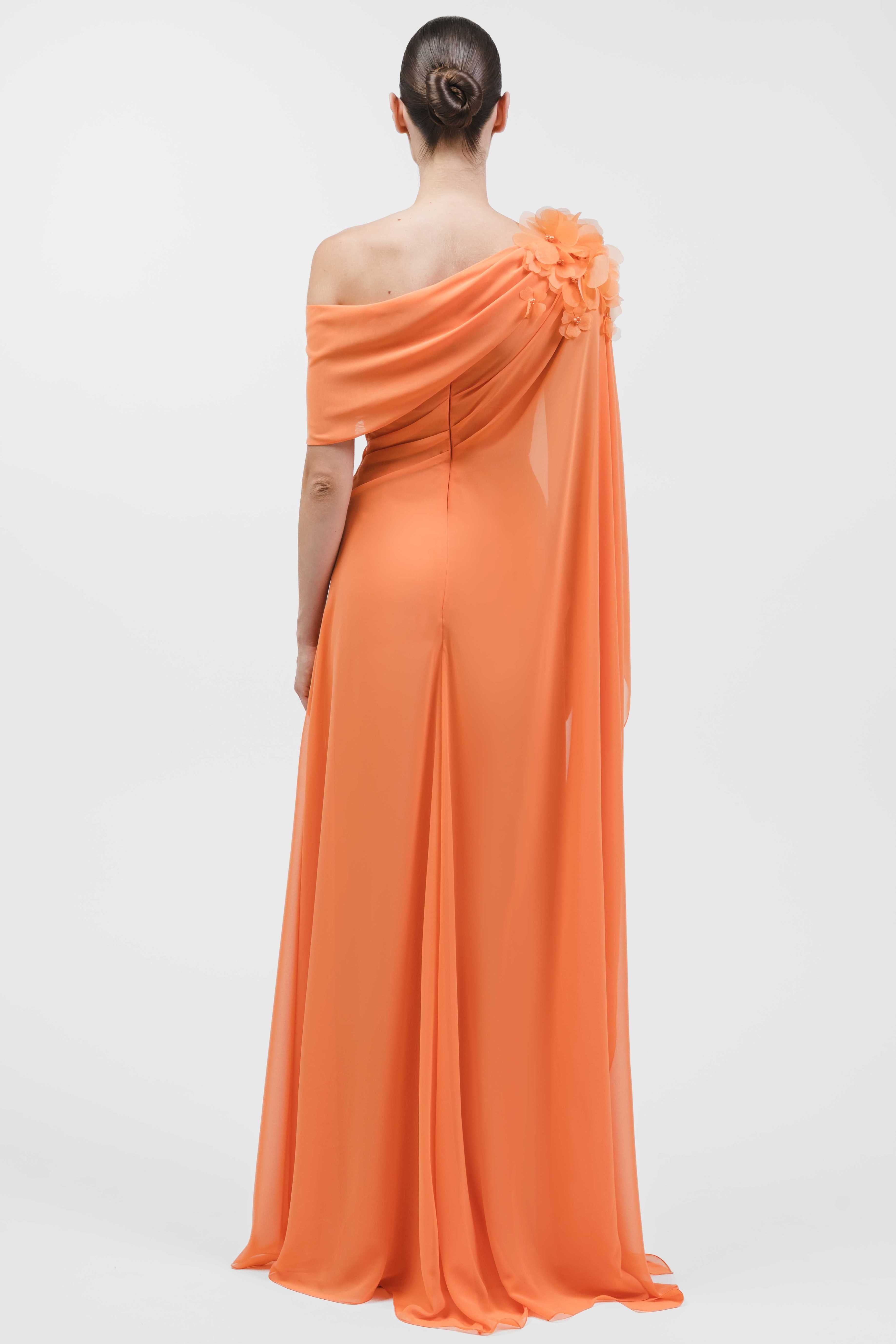 One-Shoulder Draped Muslin Gown With Floral Shoulder Detail And Side Cape.