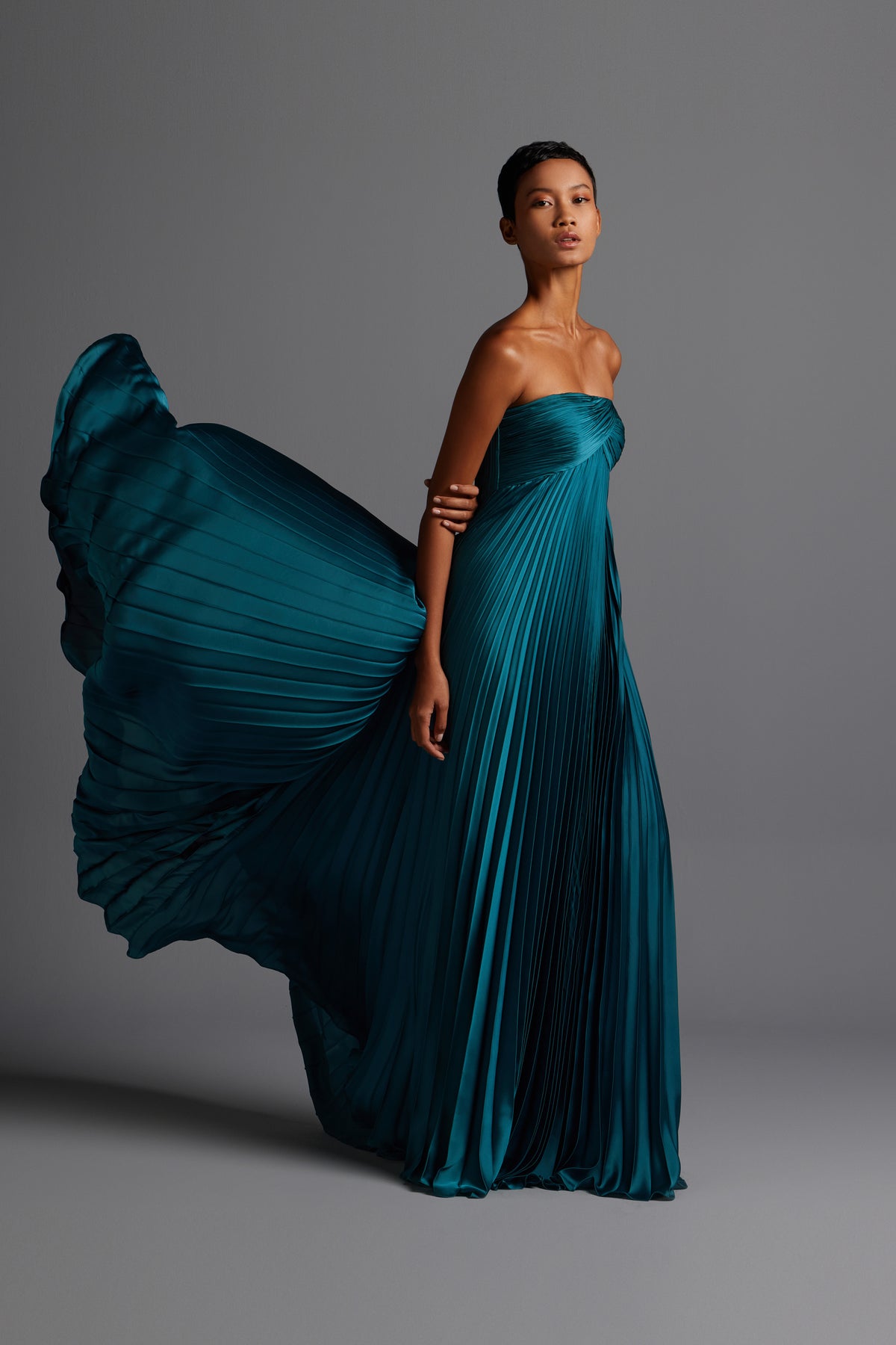 Pleated cape gown with overlapped draping